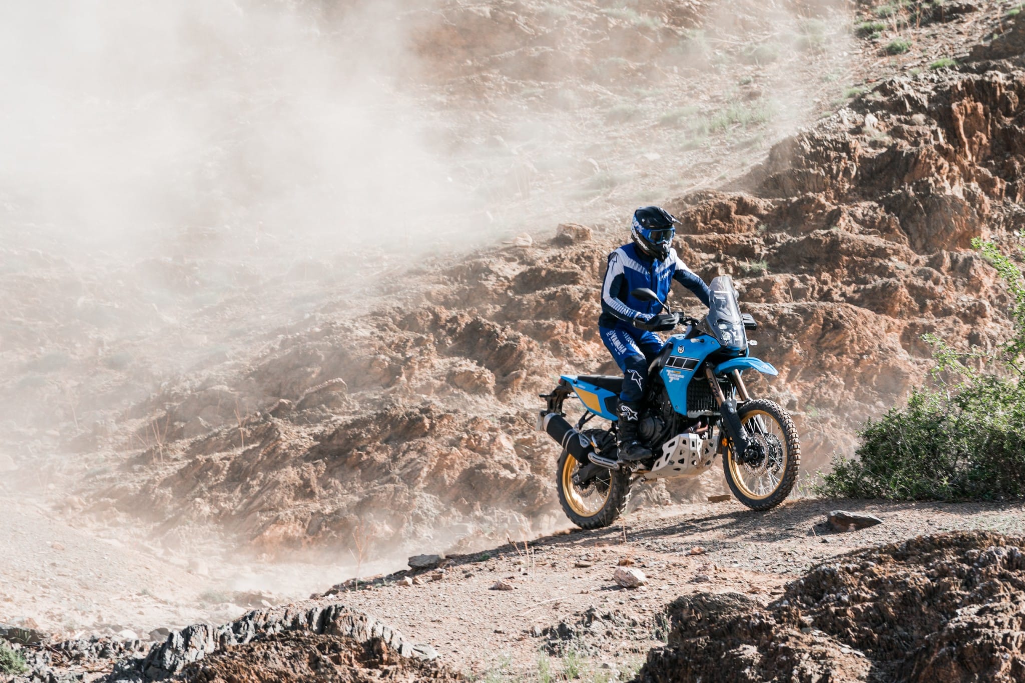 Rijder springt met de Yamaha Ténéré 700 door een stoffige rotskloof