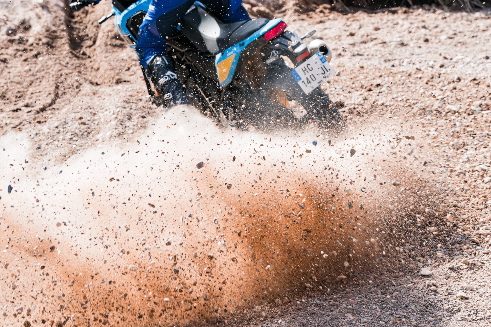Opspattend grind achter het achterwiel van de Yamaha Ténéré 700