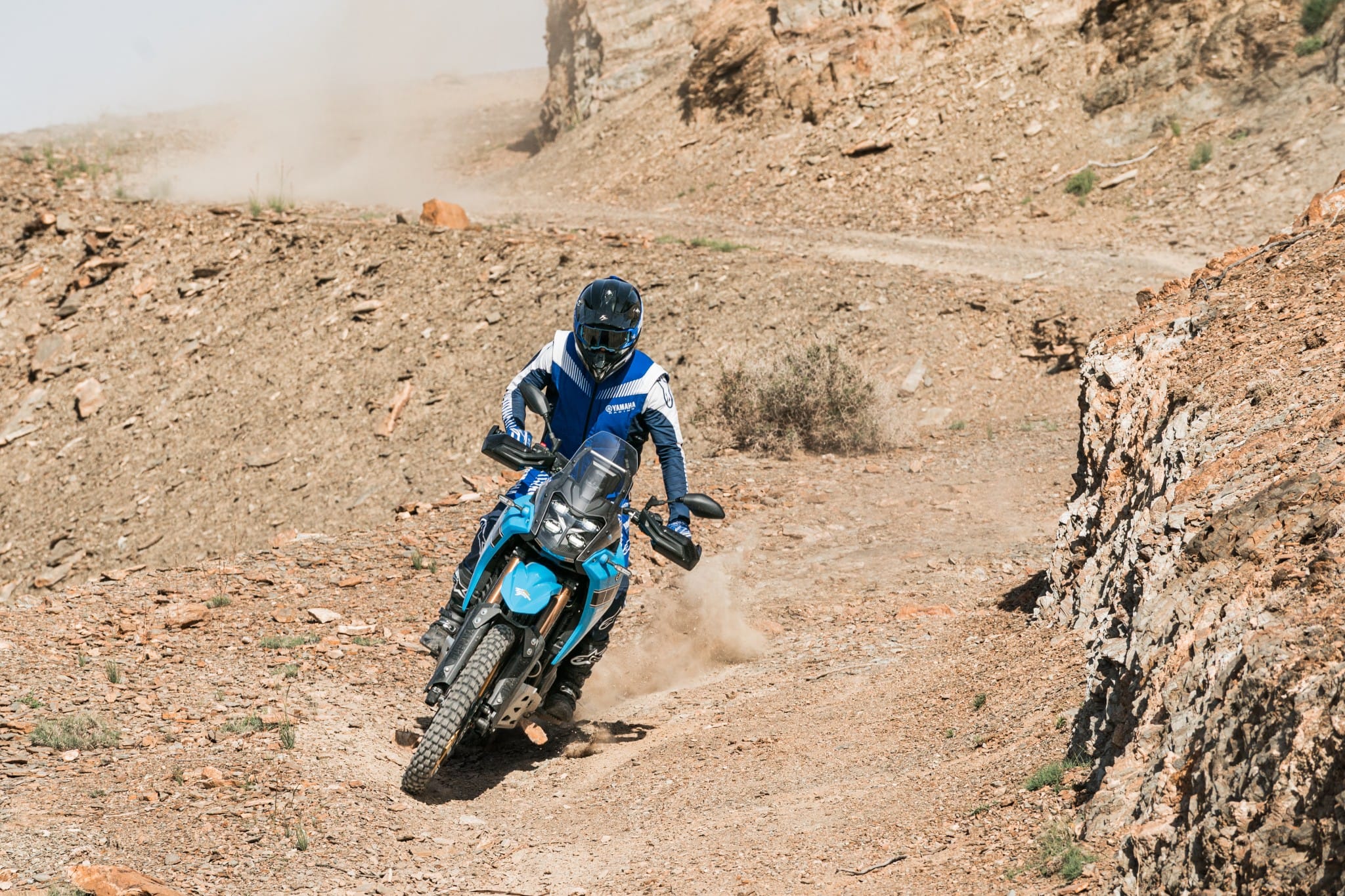 Yamaha Ténéré 700 klimt door een rotsachtige geul in de Agafay-woestijn