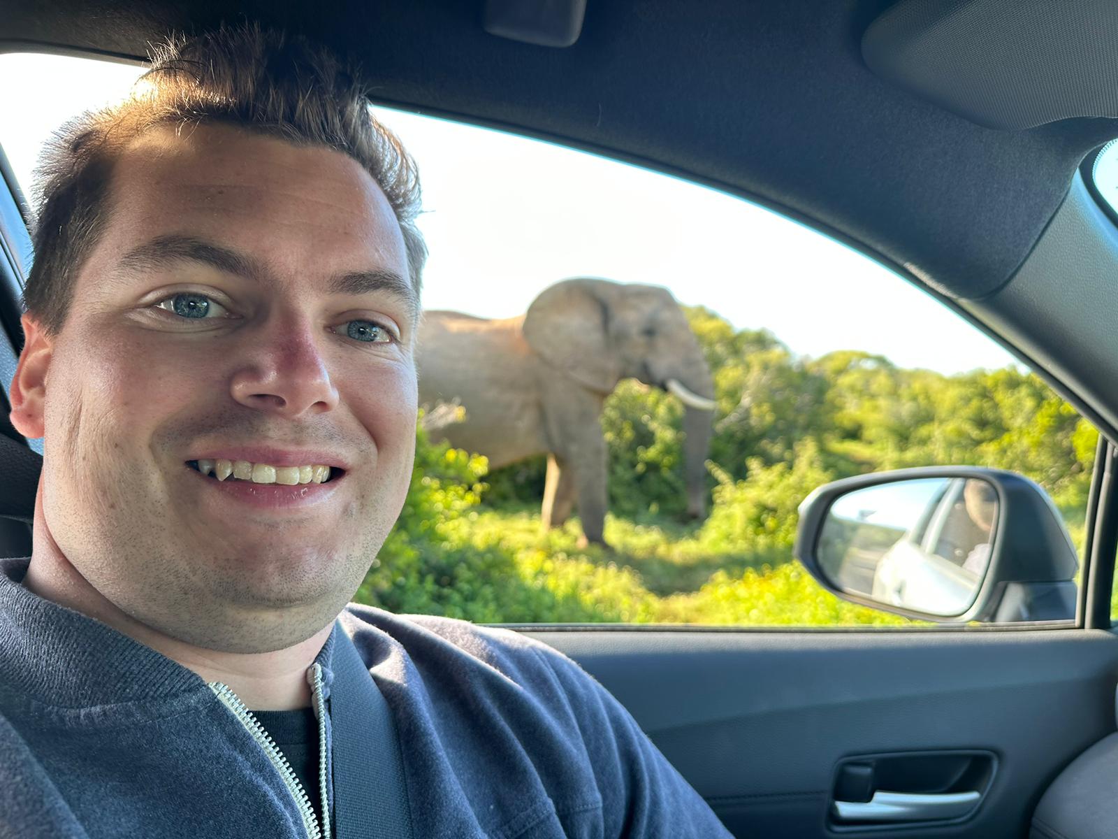 Robin Verheggen in de safariauto met een olifant vlak naast de weg
